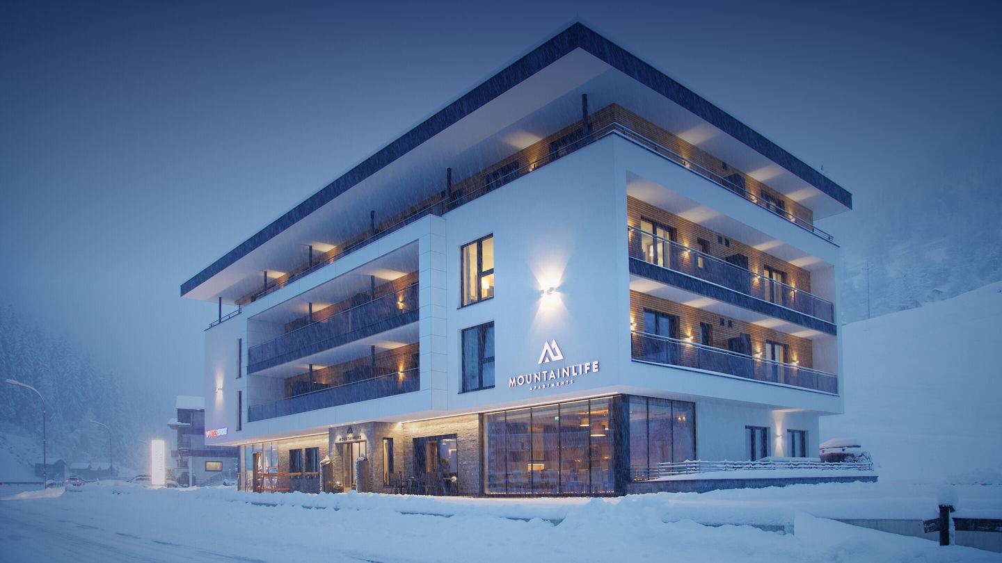 Das Haus über Eck zur blauen Stunde im dichten Schneefall, alle Balkone warm beleuchtet